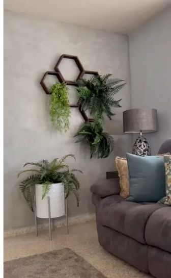 Pared en cemento pulido junto a una sala con plantas y mobiliario